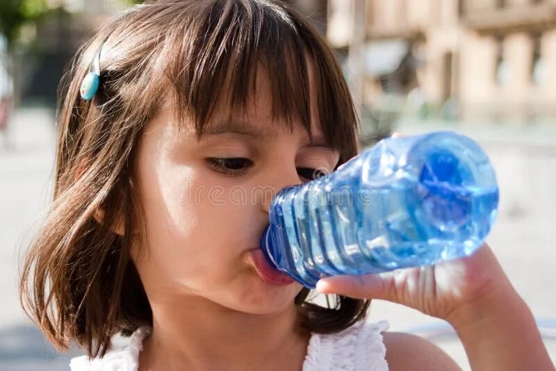 Дети пьют из бутылки. Девочка пьет воду. Ребенок пьет воду из бутылки. Девочка из бутылки воды. Девочка пьет из бутылки.