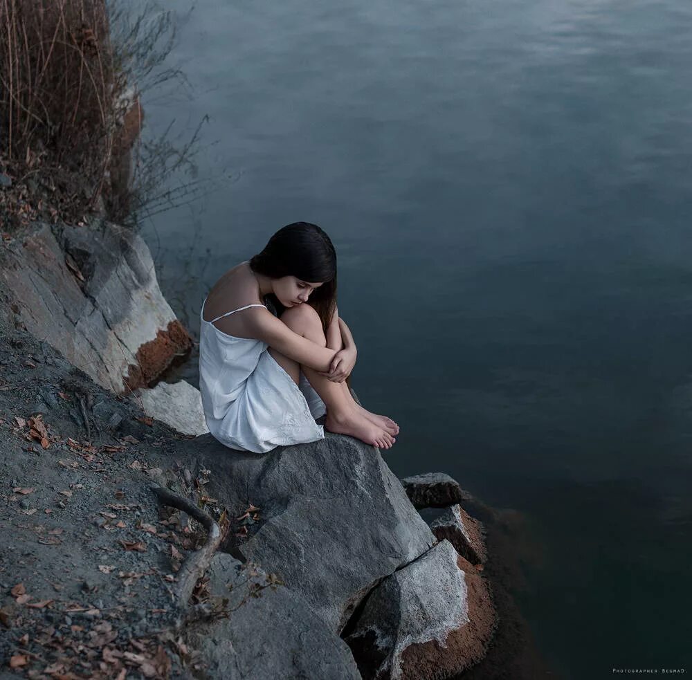 Сидела душила. Девушка на Камне. Печальная девушка. Девушка сидит у реки. Грустная девушка фото.