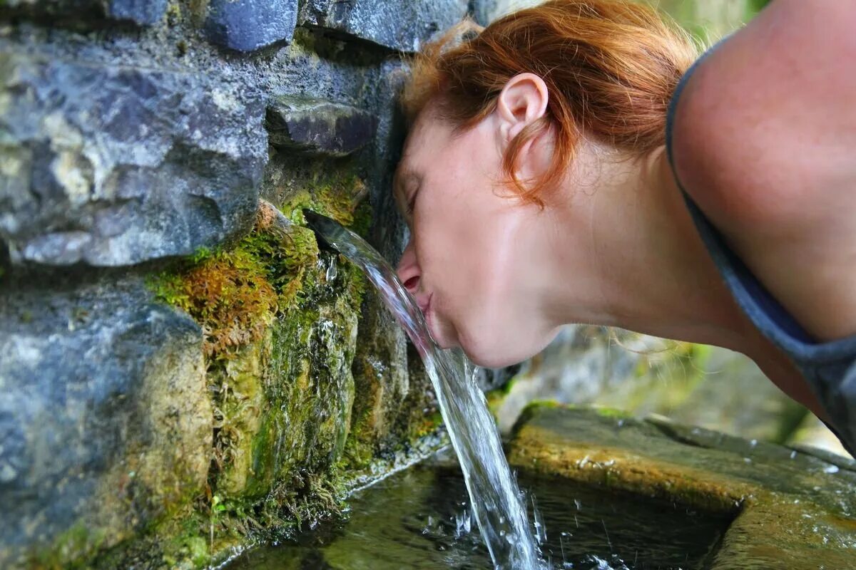 Человек пьет воду из родника. Девушка пьет из родника. Пить воду из родника. Женщина пьет воду. Пью воду и писаю