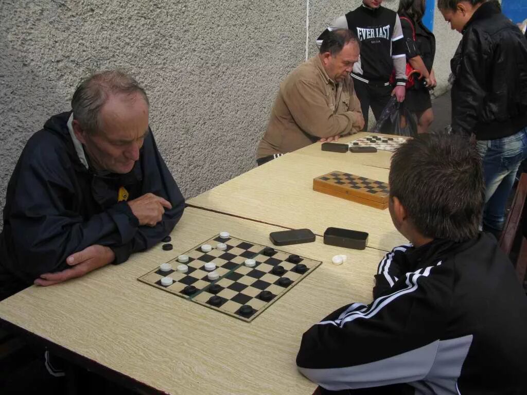 Пожилые играют в шашки. Человек который играет в шашки. Ребенок, играющий в шашки. Игрок в шашки. Шашки соревнования.