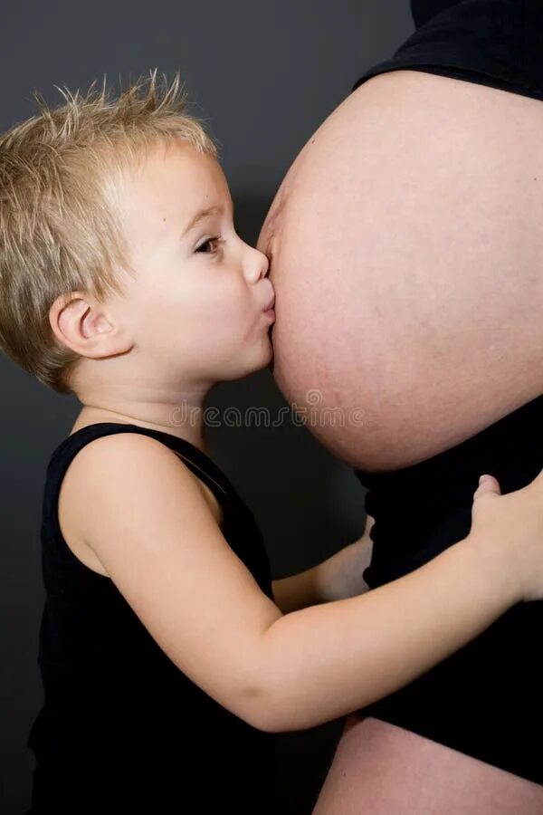 Мама целует малыша. Мальчик целует мамин живот. Поцеловать малыша в животик. Целует живот.