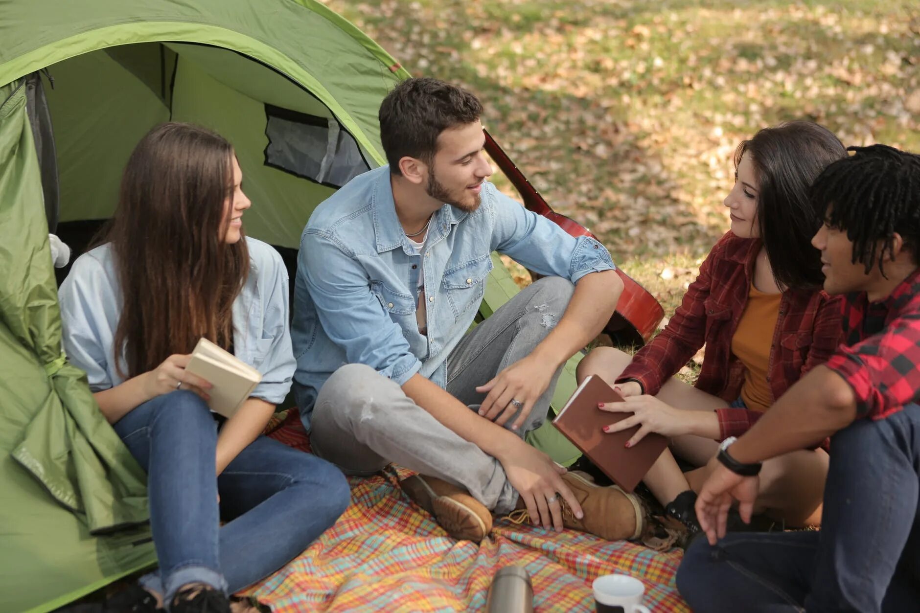 Camp right. Люди разговаривают на участке. Отдыхаем, беседа. Друзья сидят общаются фото.