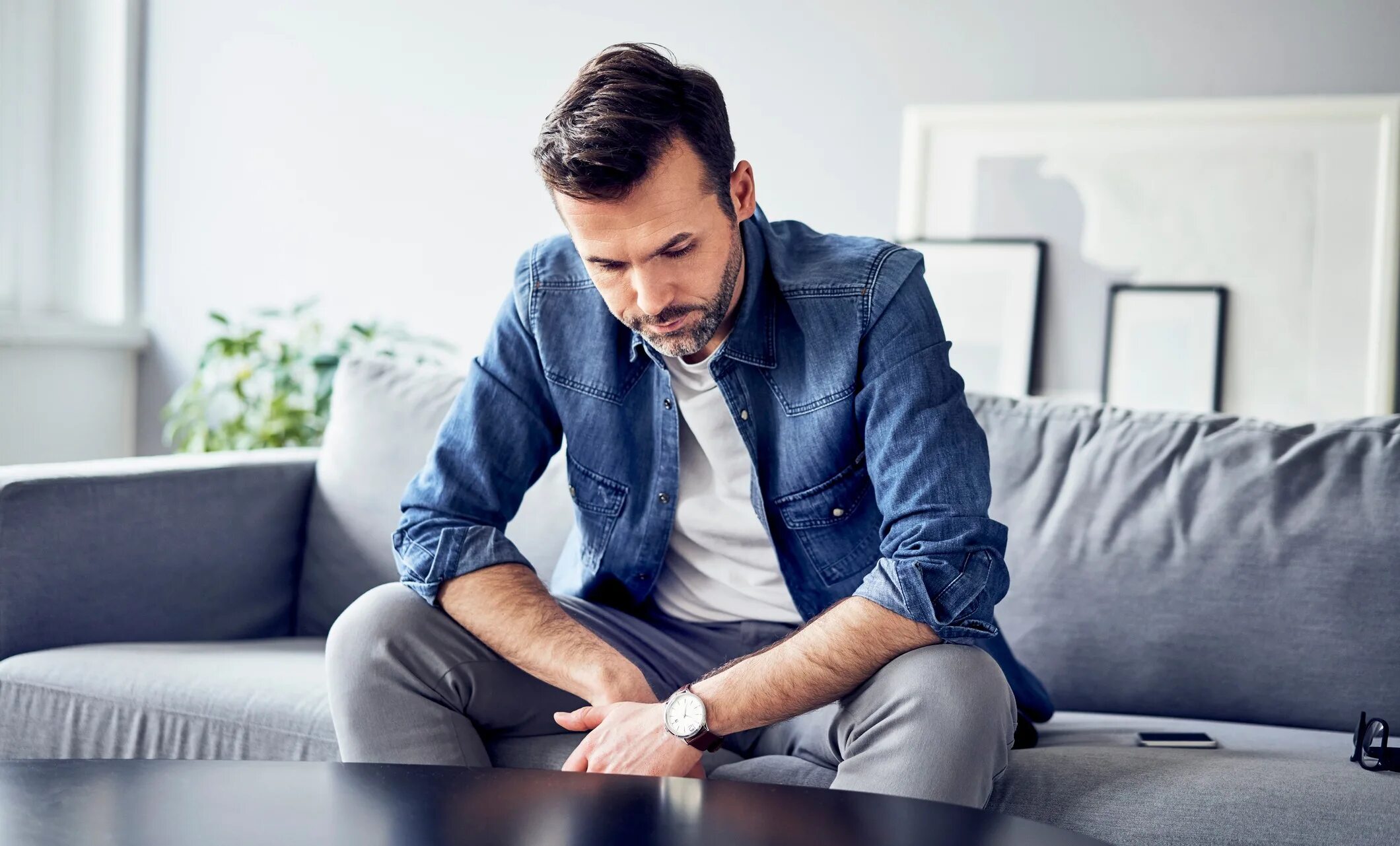 Человек отдыхает. Мужчина сидит. Скука в отношениях. Скучно в отношениях. Парень на диване.