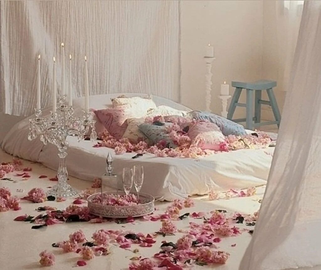 Романтичная постель. Лепестки роз на кровати. Спальня для молодоженов. Кровать усыпанная лепестками роз. Брачная ночь украшение комнаты.