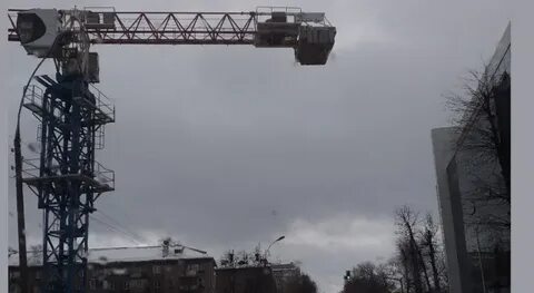 Башенный кран поднимает бетонную плиту массой