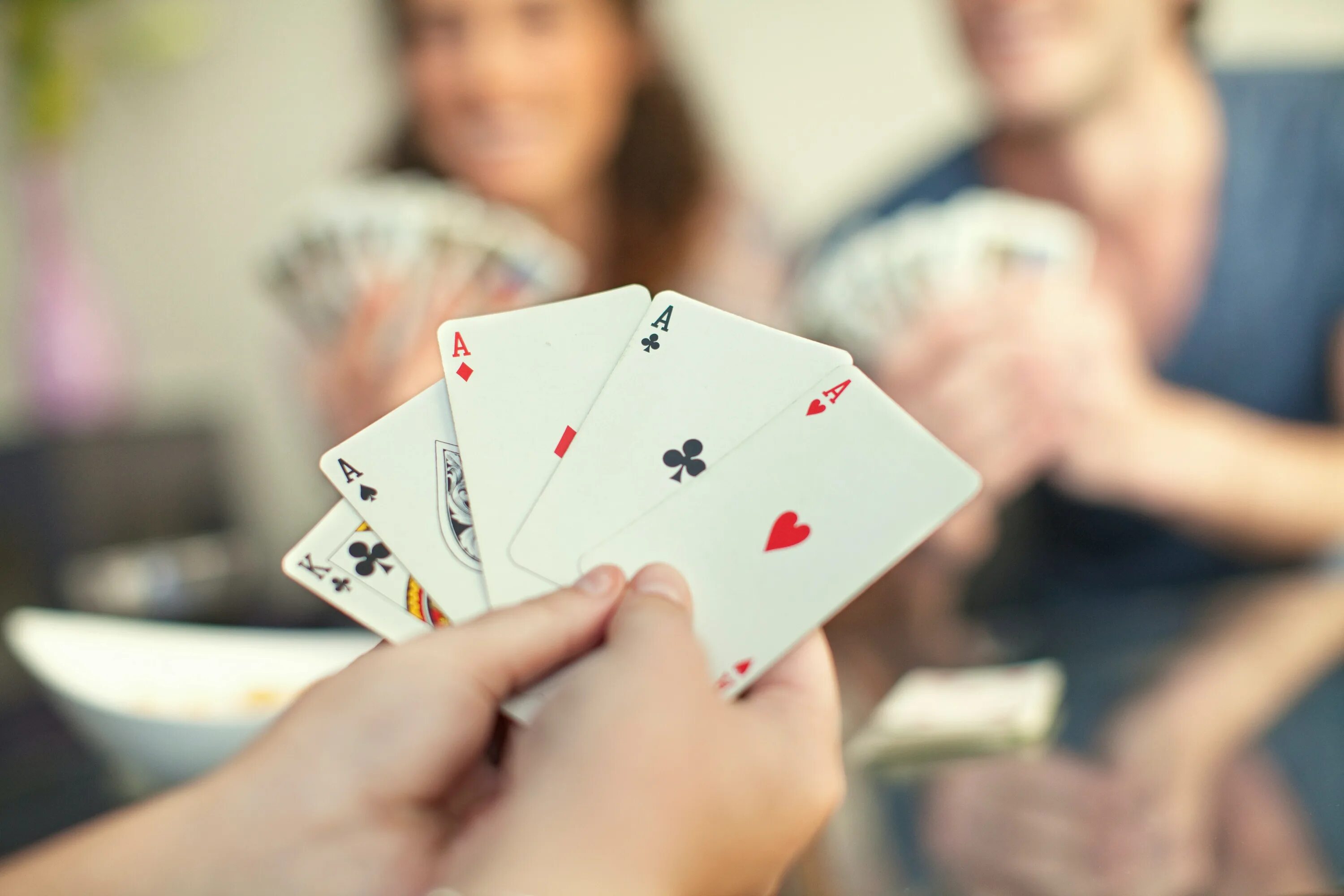 Playing with magic. 4 People playing Cards. Sexy игральные карты с девушками. Hands holding playing Cards. Play Cards stock pic.