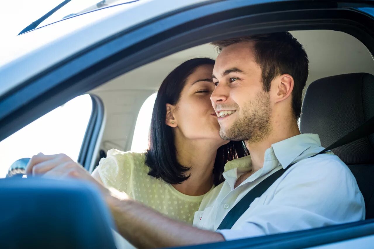 Дает в машине мужу. Счастливая пара в автомобиле. Счастливая молодая пара в машине. Мужчина целует машину. Пара мужчина и женщина в машине.