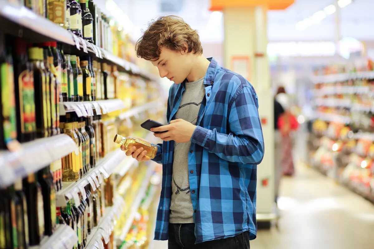 Beautiful couple having fun while choosing food in the supermarket Фотографія St