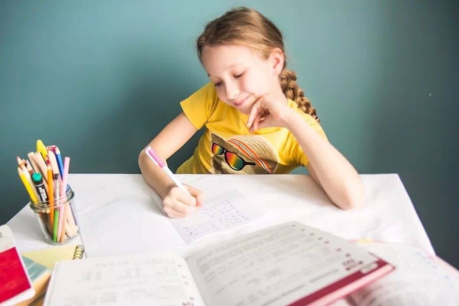 Девочка делает уроки. Девочка делает домашнюю работу. Девочка домашнее задание. Ребенок за уроками. Дети за учебой.