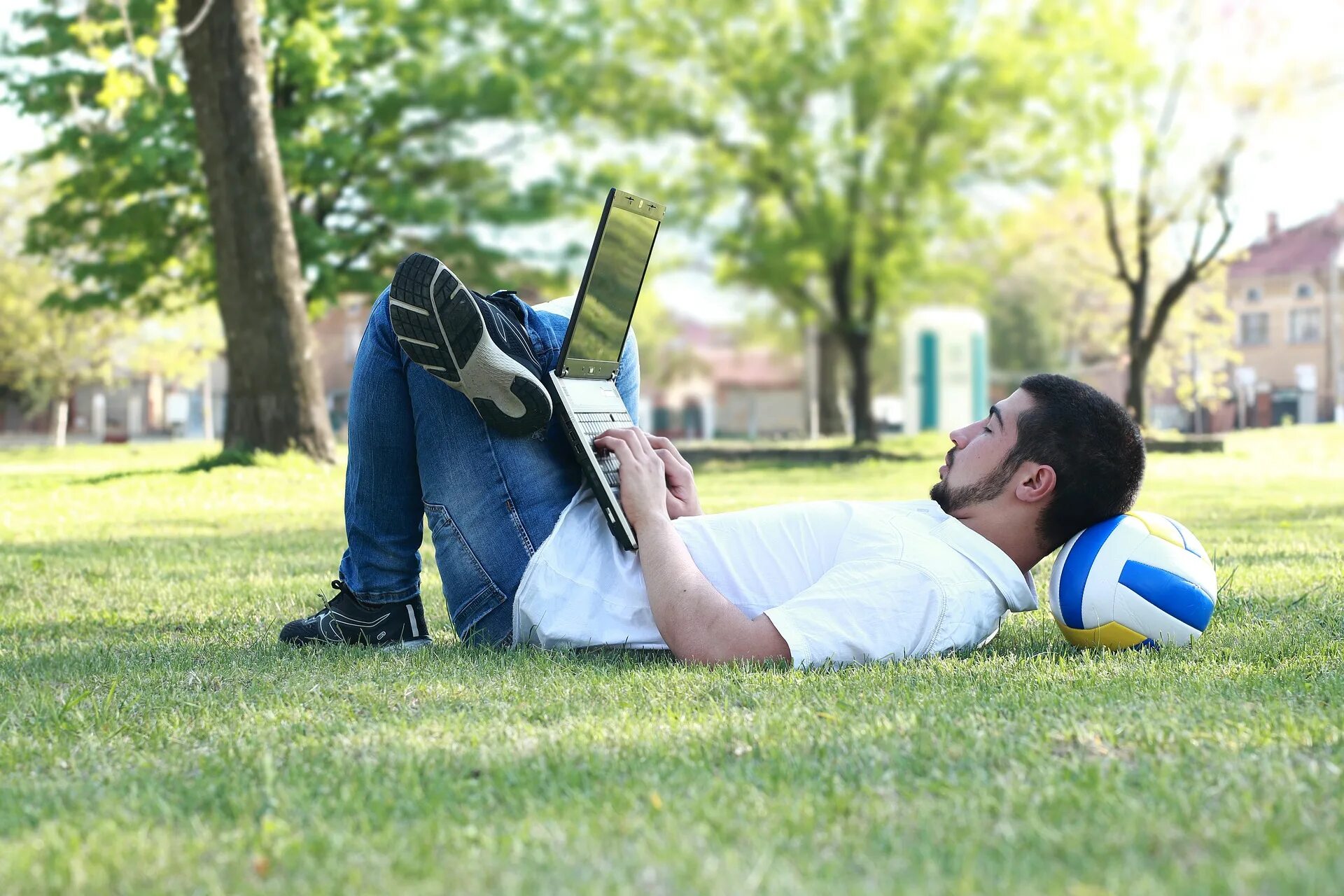 Люди в парке. Человек с компьютером на улице. Лежит в парке. Айтишники на природе.