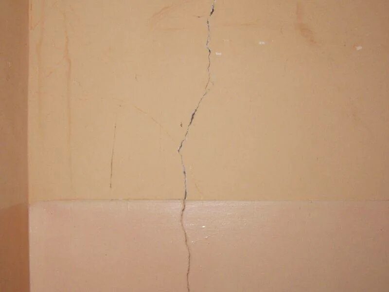На стене появились трещины. Трещины в перегородках. Дефект трещины стены. Трещины на штукатурке. Мелкие трещины на стене.