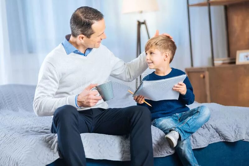 Мама хвалит ребенка. Мама хвалит ребенка. Отец гладит. Отец обнимает сына на диване. Папа треплет сына по голове.