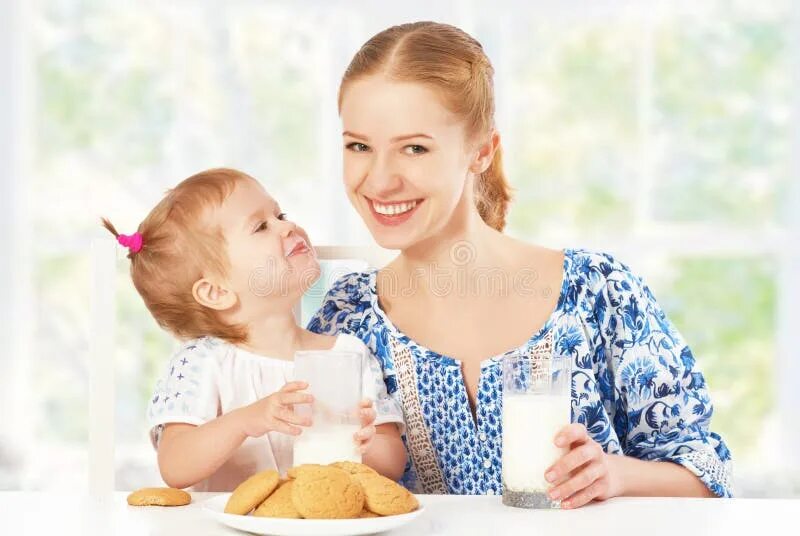 Daughters milk. Мама с маленькой дочкой завтракают. Дочь мелко дочи Milk. Девочка пьет молоко с печеньем на завтрак. Happy Family Milk.