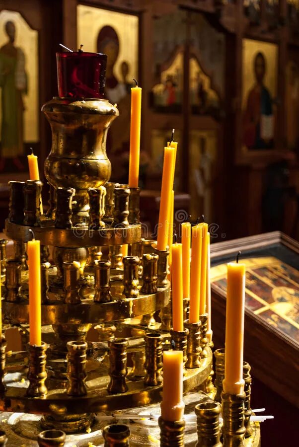 церковь внутри свечки. алтарь со свечами. свечка у иконы в храме. католическое христианство. свечи в храме в темноте.