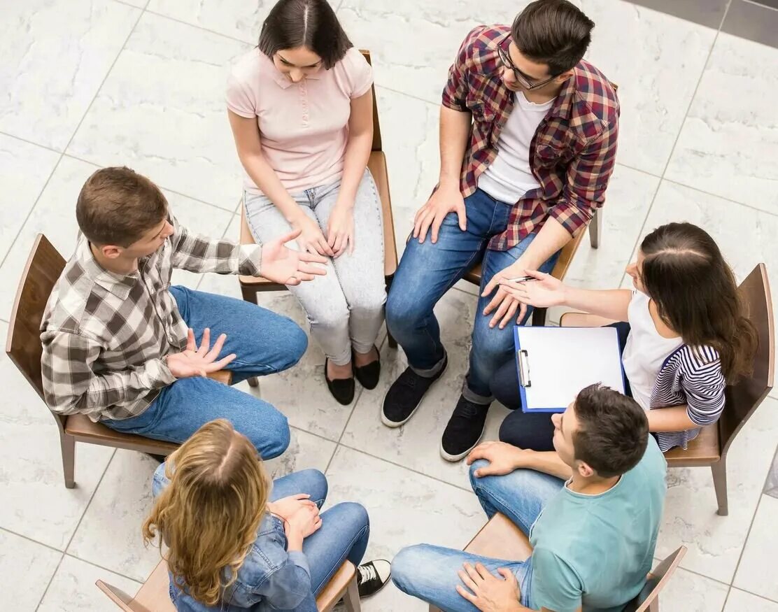 Люди сидят в кругу. Групповые занятия с психологом. Терапевтическая группа. Групповая психотерапия. Групповая работа психотерапия.