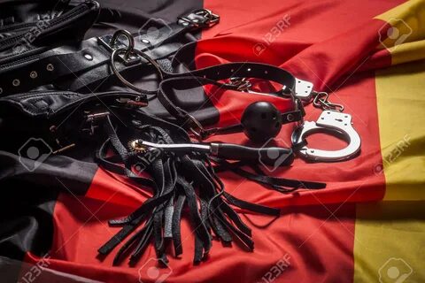 Bdsm toys for pain and pleasure laying on german flag.