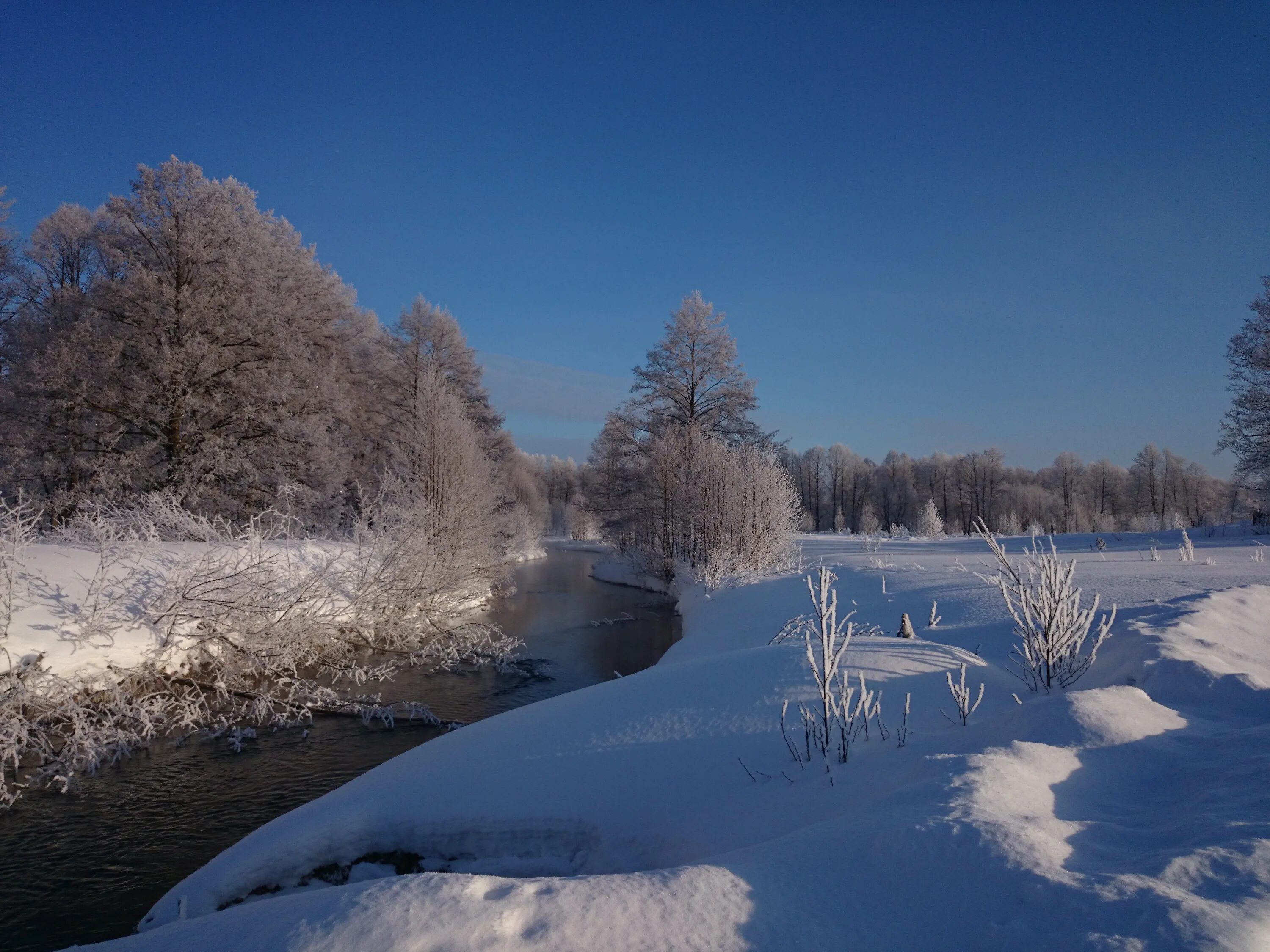 Зима картинки. Зимний пейзаж с речкой. Мороз речка. Зимний пейзаж с рекой фото. Где умеренно холодная снежная зима