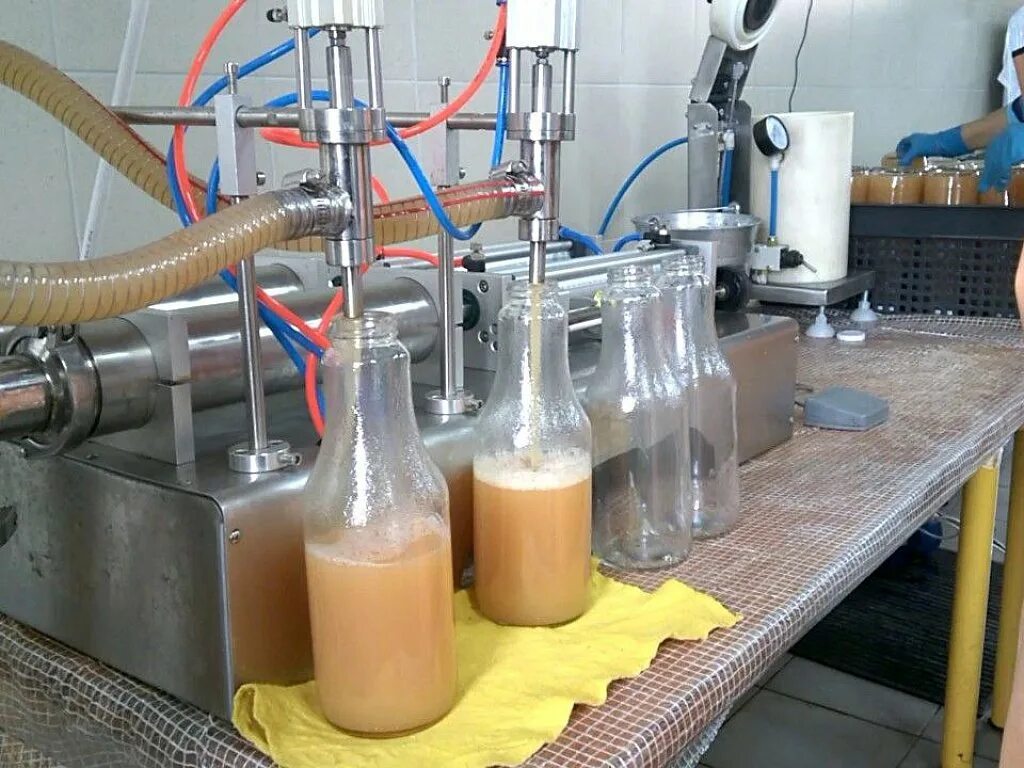 Сок разливают по бутылкам. Линия горячего розлива соков. Сок на розлив. Производство сока. Сок разливают по бутылкам.