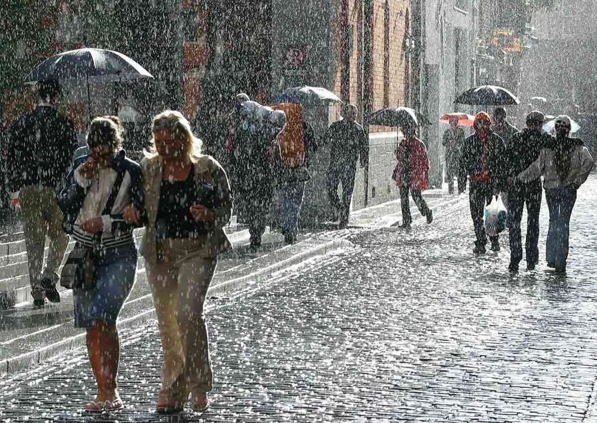 Дождливый день. Люди под дождем в городе. Холодное дождливое лето. Человек под дождем.