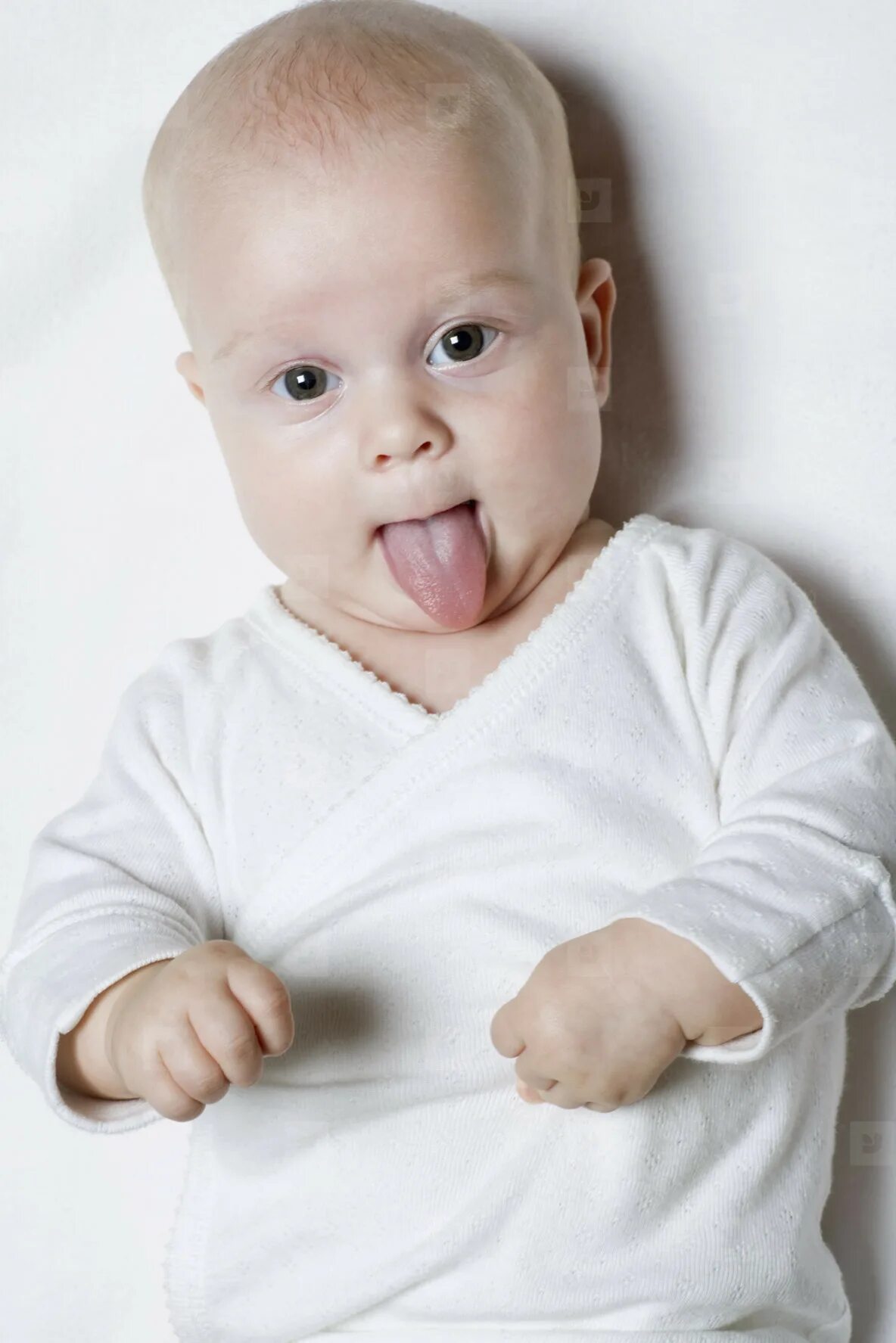 Ребенок с высунутым языком. Младенец высовывает язык. Грудничок высовывает язык. Ребенок с высунутым языком фото.