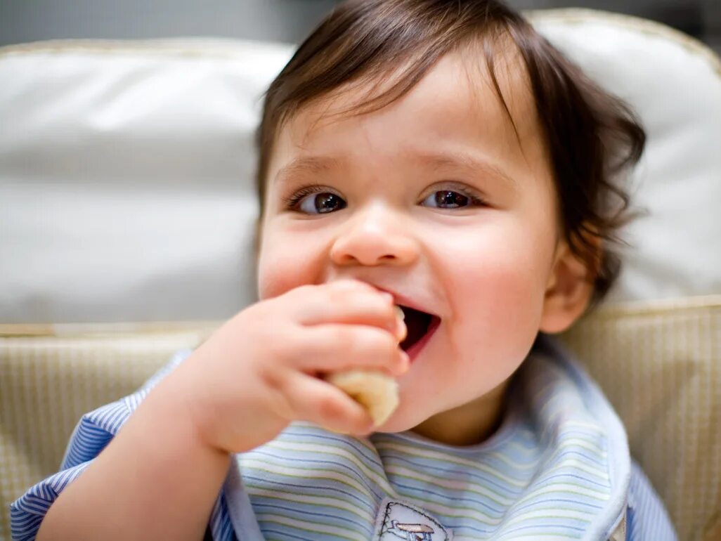 A treats children. Мягкий зуб у годовалого ребенка. Baby eating. Картинка ребенок тянется к зубам.