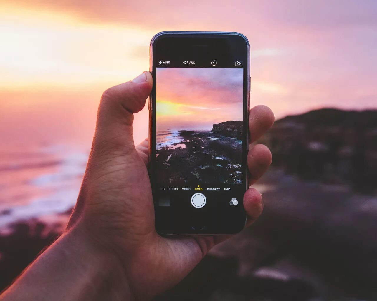 Снять закат. Фотограф на закате. Фотографирую закат. Закат снимают. Смартфон на море.