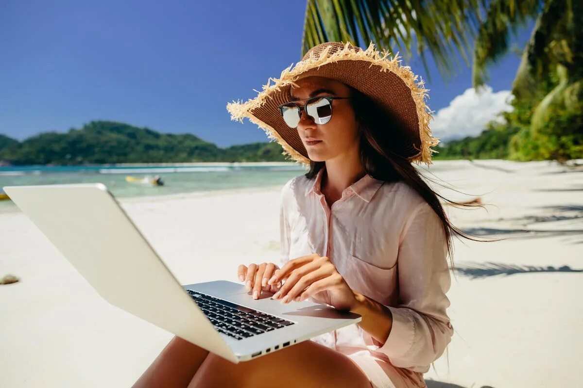 Digital nomad виза. Девушка с ноутбуком на пляже. Женщина фрилансер. Фрилансер на пляже. Азиатка с ноутбуком на море.