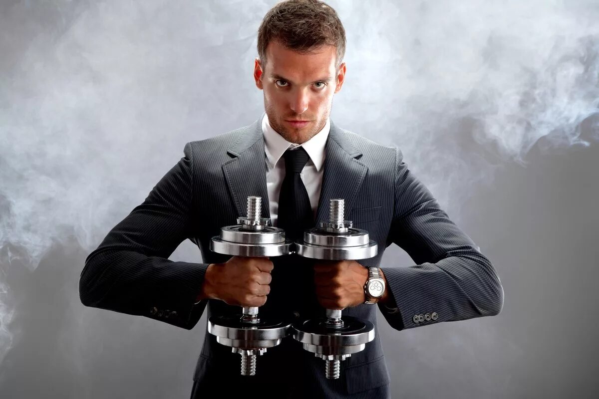 спортивный бизнесмен. спортивный бизнесмен. спортивный парень в деловом костюме. бизнесмен с гантелей. человек на низком старте.