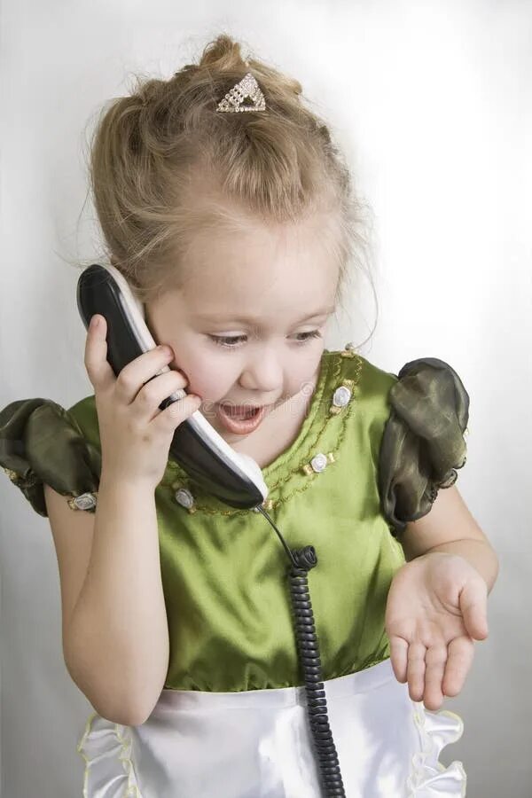 Пока дочь разговаривает по телефону. Девочка разговаривает по телефону. Ребенок говорит по телефону. Девочка говорит по телефону. Радостный ребенок с телефоном.