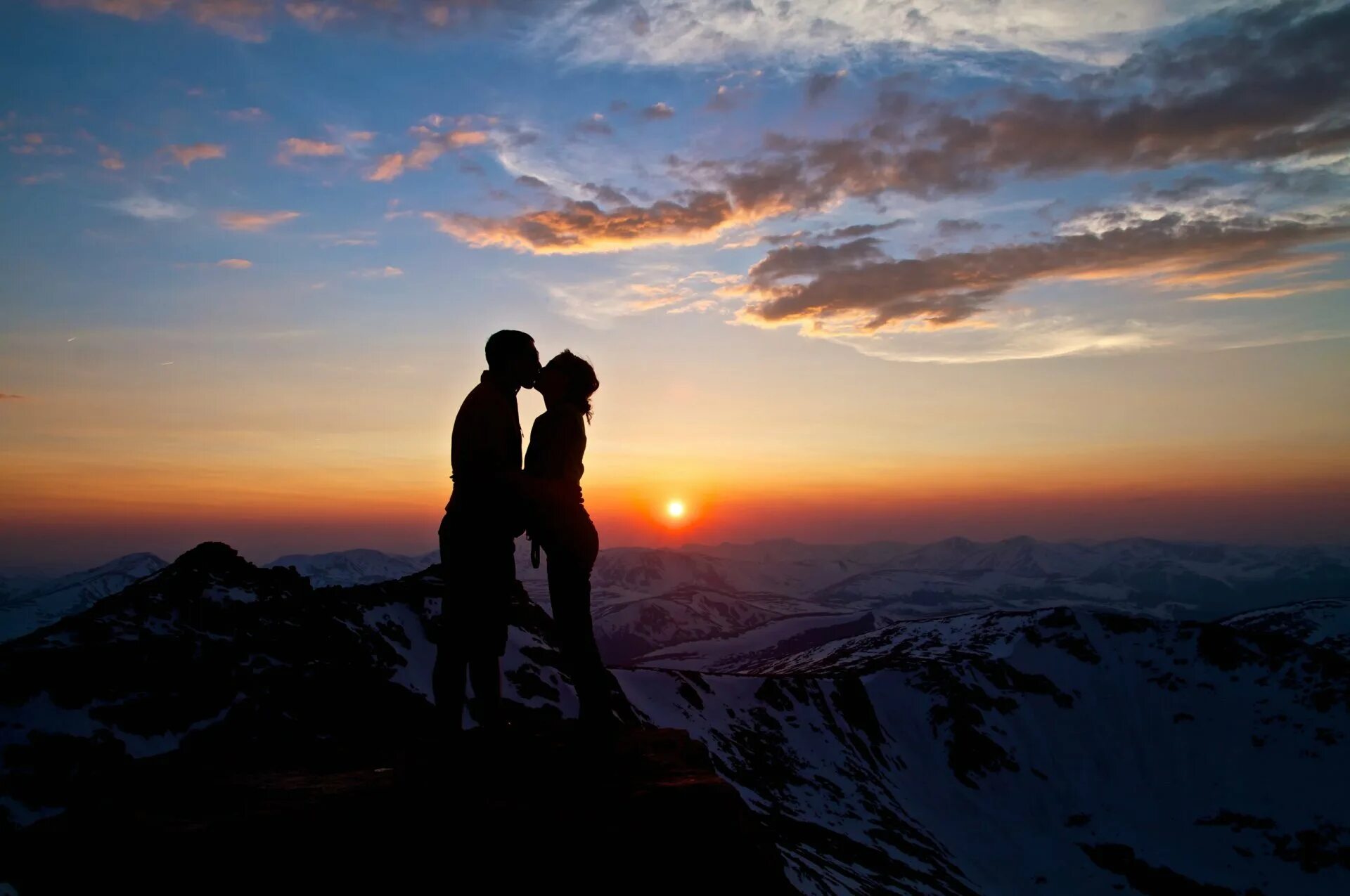 Светимся вместе. Пара в горах. Двое на вершине горы. Влюбленные на закате. Переньи девушка в горах.