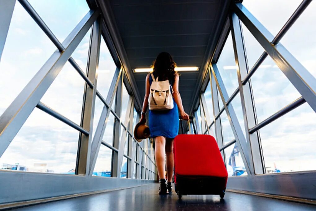 Young female passenger at the airport, using her tablet computer while waiting f