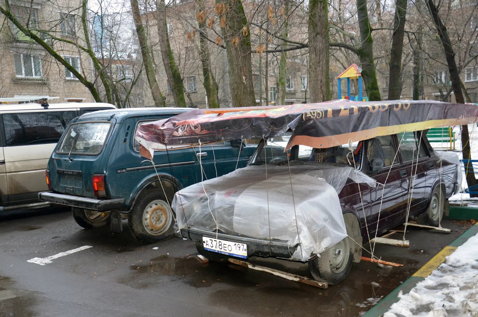 Машина в снегу на парковке. Машины зимой на стоянке. Машины зимой на стоянке. Навес для автомобиля зимний. Оставить машину на зиму на улице.