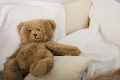 The green bear is on the bed