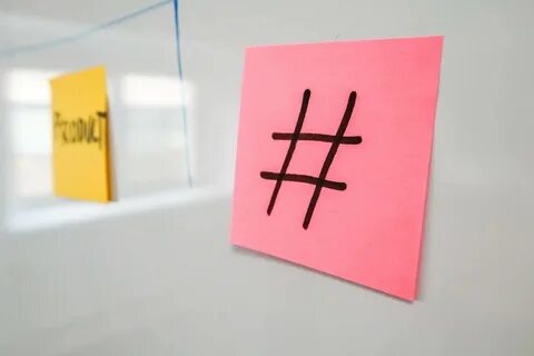 Image showing a hashtag sign on a post it placed on a white board. 