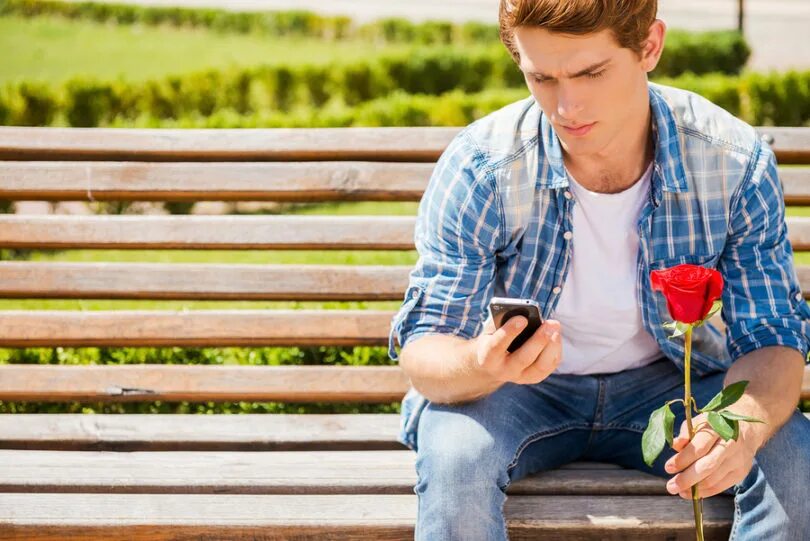 He is why waiting. Человек сидит в телефоне. человек держит вас. man waiting. парень с цветами в руках на лавочке.