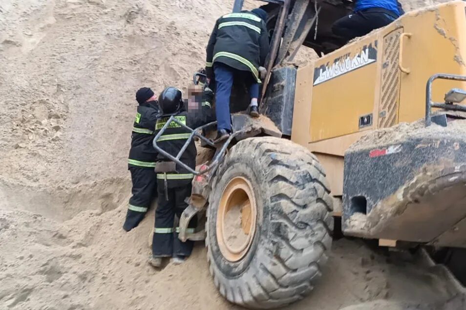 Достали ли горняков в амурской области. Рабочие засыпают песок. Погрузчик в карьере. Засыпало песком в карьер. Погрузчик придавил водителя.