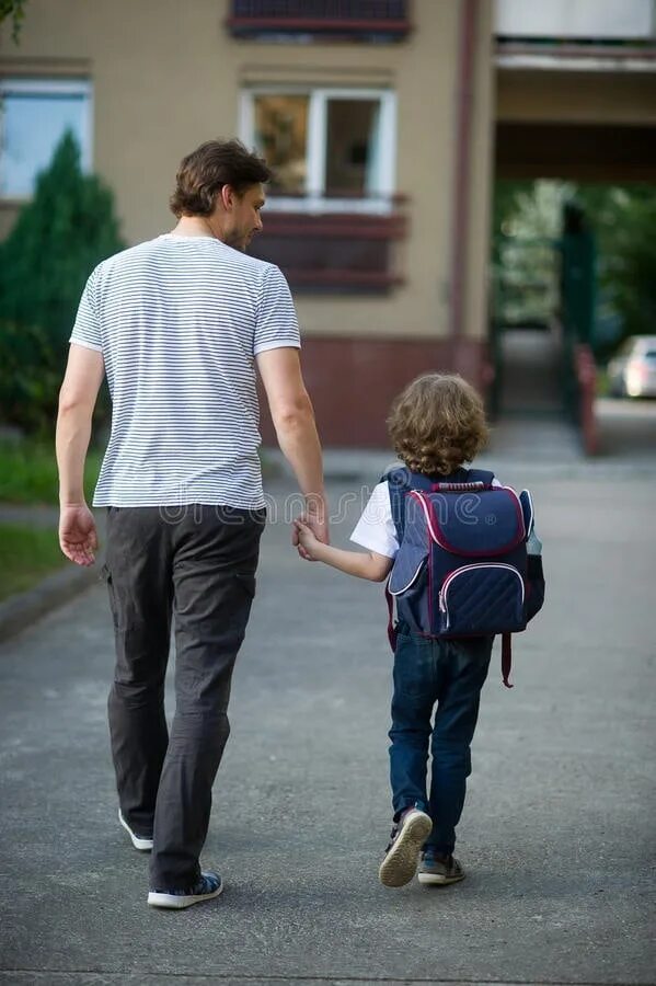 Ребенок с портфелем. Ученик с родителями. Со школы и с отцом. Ребенка ведут за руку. Мама ведет ребенка в школу.