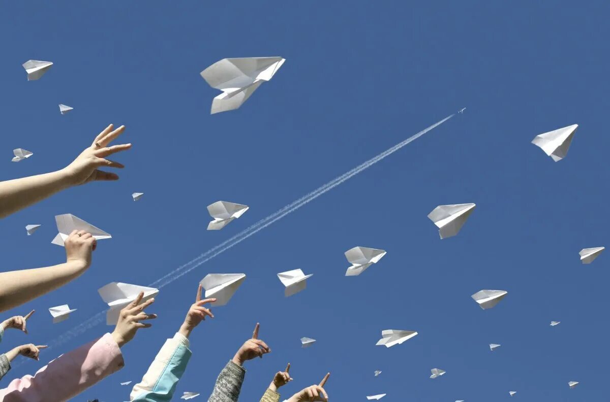 Бумажный самолетик. Бумажный самолетик в небе. День бумажных самолетиков. Запускает бумажный самолетик.