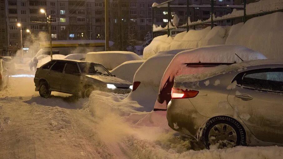 Заснеженная парковка. Парковка в снегу. Парковка на сугробе. Машины паркуются в снегопад.