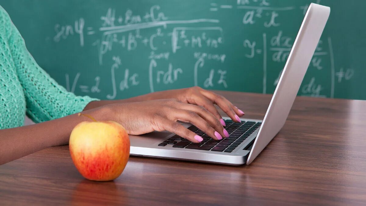 Учитель и компьютер. Педагог с ноутбуком. Педагог за компьютером. Учитель в школе за компьютером.