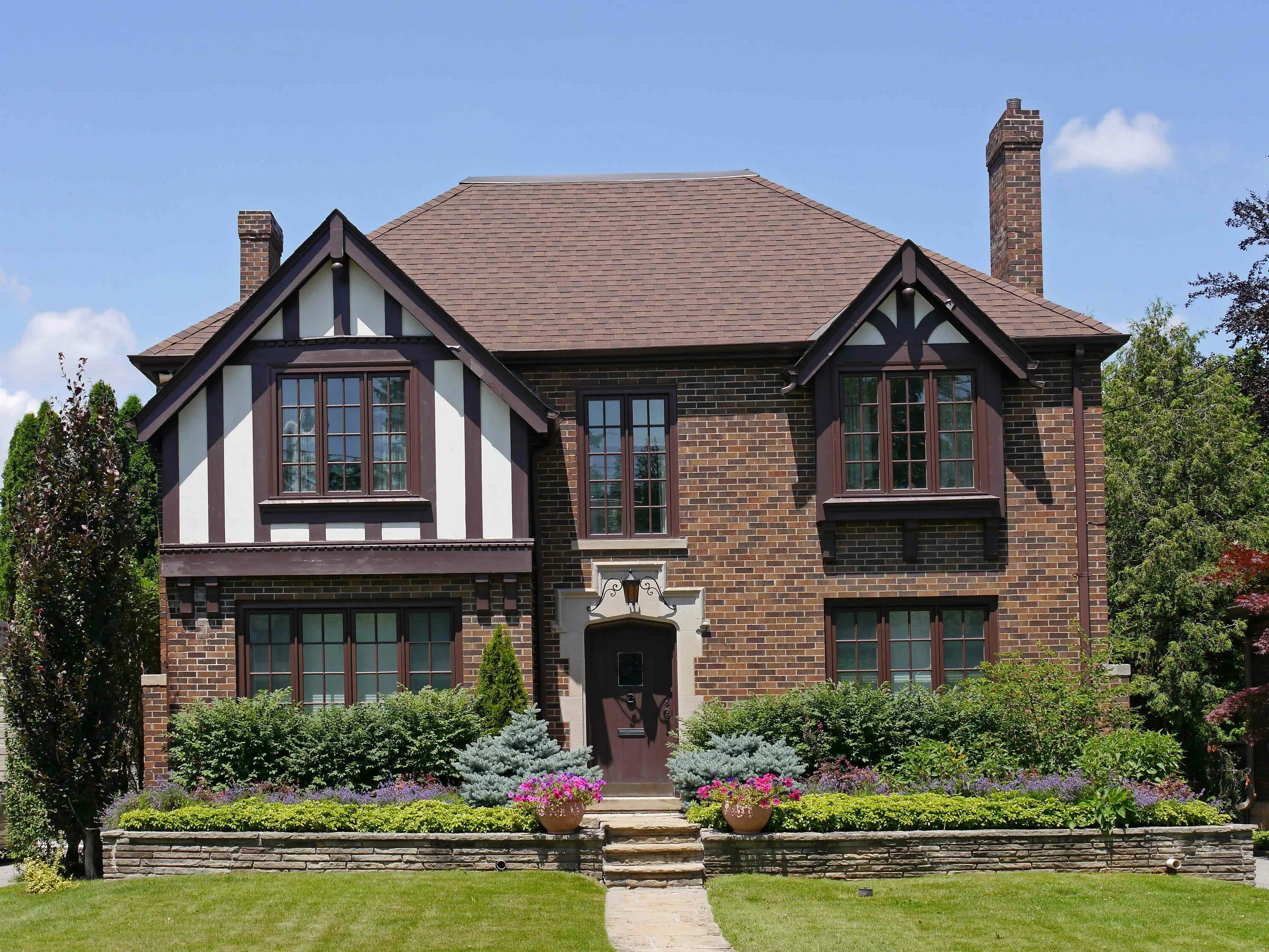 Английский дом купить. Особняк Тюдоров в Англии. Стиль Тюдор (Tudor Revival Cottage). Стиль Нео Тюдор в архитектуре. Дом архитектура в английском Тюдор стиле темный кирпич.