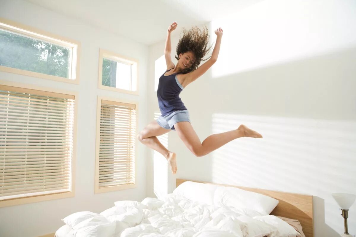 Девушка в прыжке. Девушка прыгает. Девушка прыгает на кровати. Бодрость утром. Эмоциональный подъем это