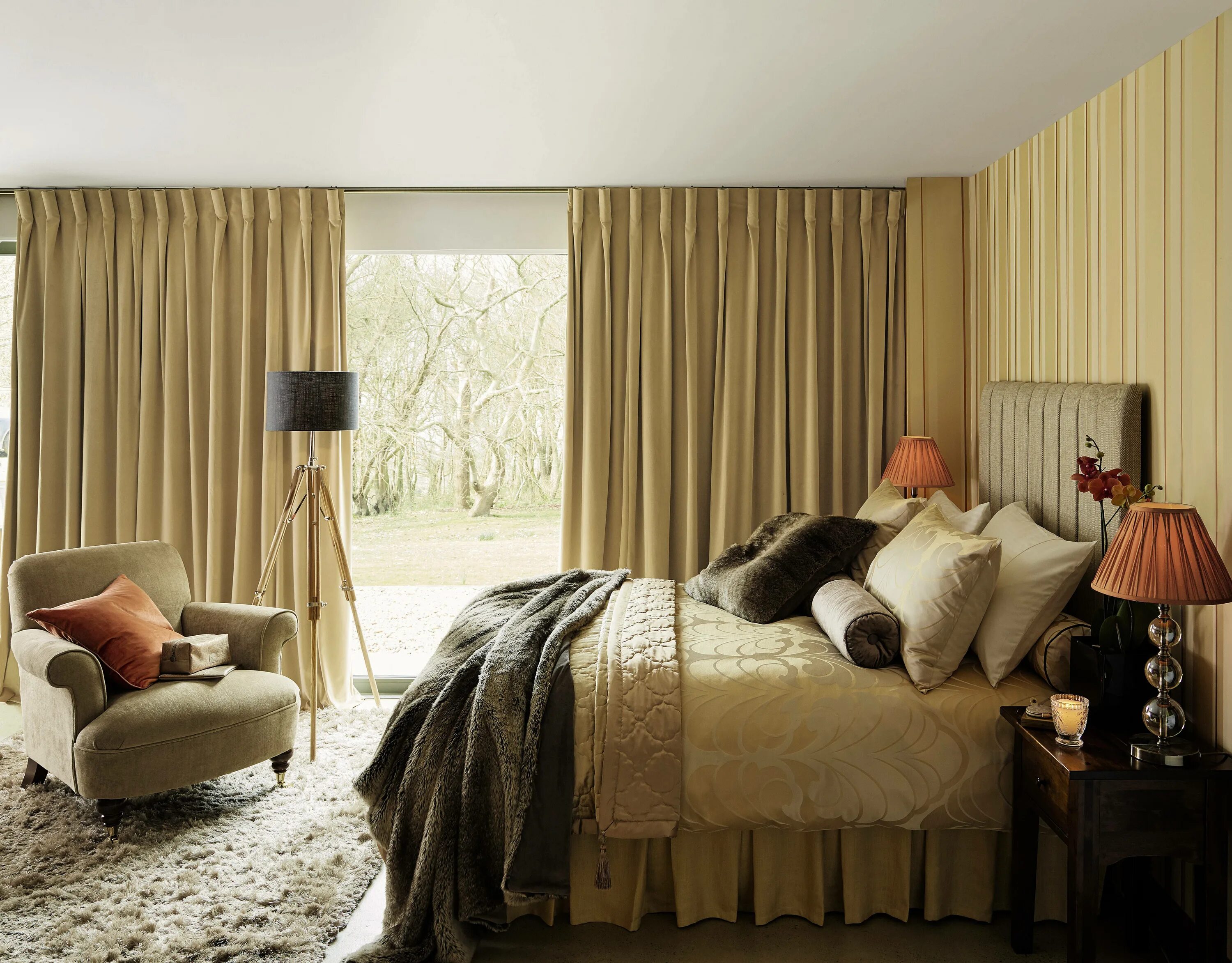 The long blue curtains and the chairs found in this room, create a cool color sc