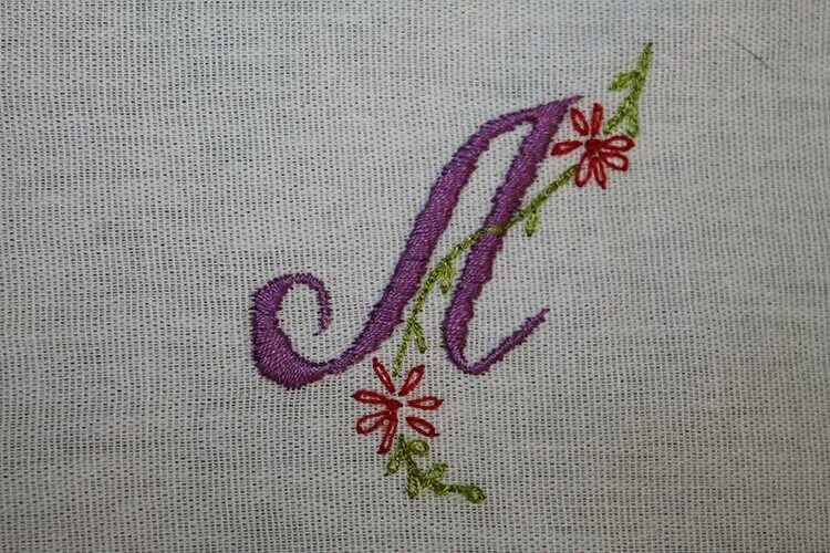 вышивка на ткани нитками буквы.
