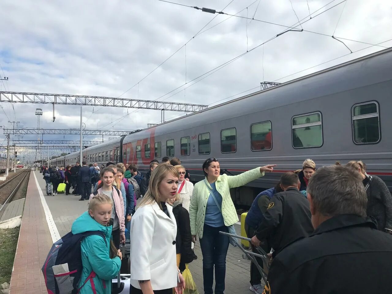 Вдоль стоящего на станции пассажирского поезда идёт обходчик впр. Отцепленный вагон. Вдоль стоящего на станции пассажирского поезда идёт обходчик. Девушки в метро. Люди на вокзале.