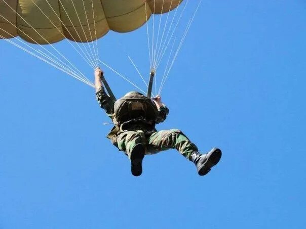 Спортсмен спускаясь на парашюте. Парашютист ВДВ. Десантник с парашютом. Парашютист военный десантник. Парашют лётчика.