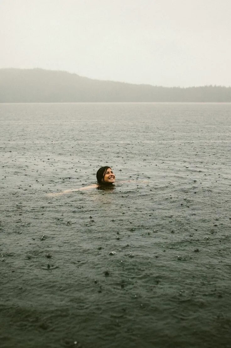 Плавать в дождь. Купание под дождем. дождь на море. купаться в море под дождем. девушка купается в море.