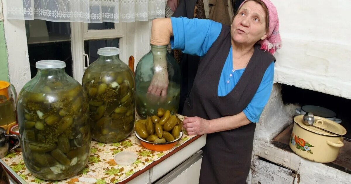 Бабуля с огурцами в банках. Бабка с банками. Женщина закручивает банки. Бабушка с банками.