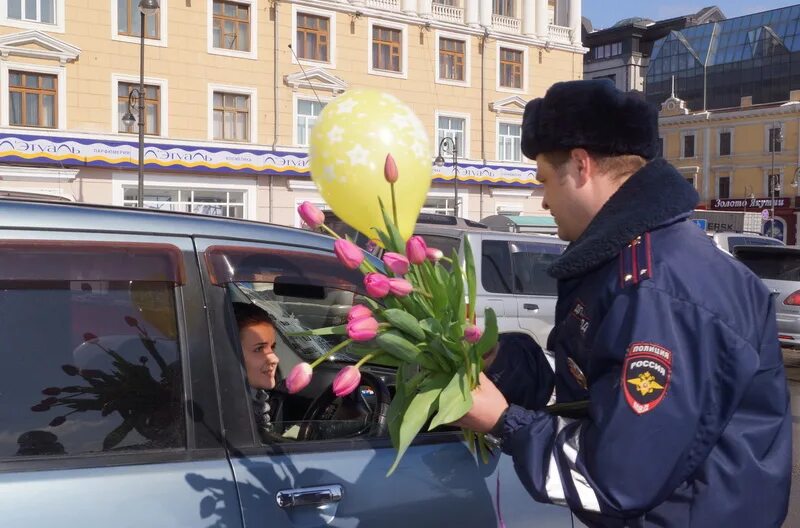 Сотрудники ГИБДД Уфа. Сотрудники ГИБДД Владивосток. Полицейский дарит цветы. День сотрудника ГИБДД подарки. Гибдд дарит цветы