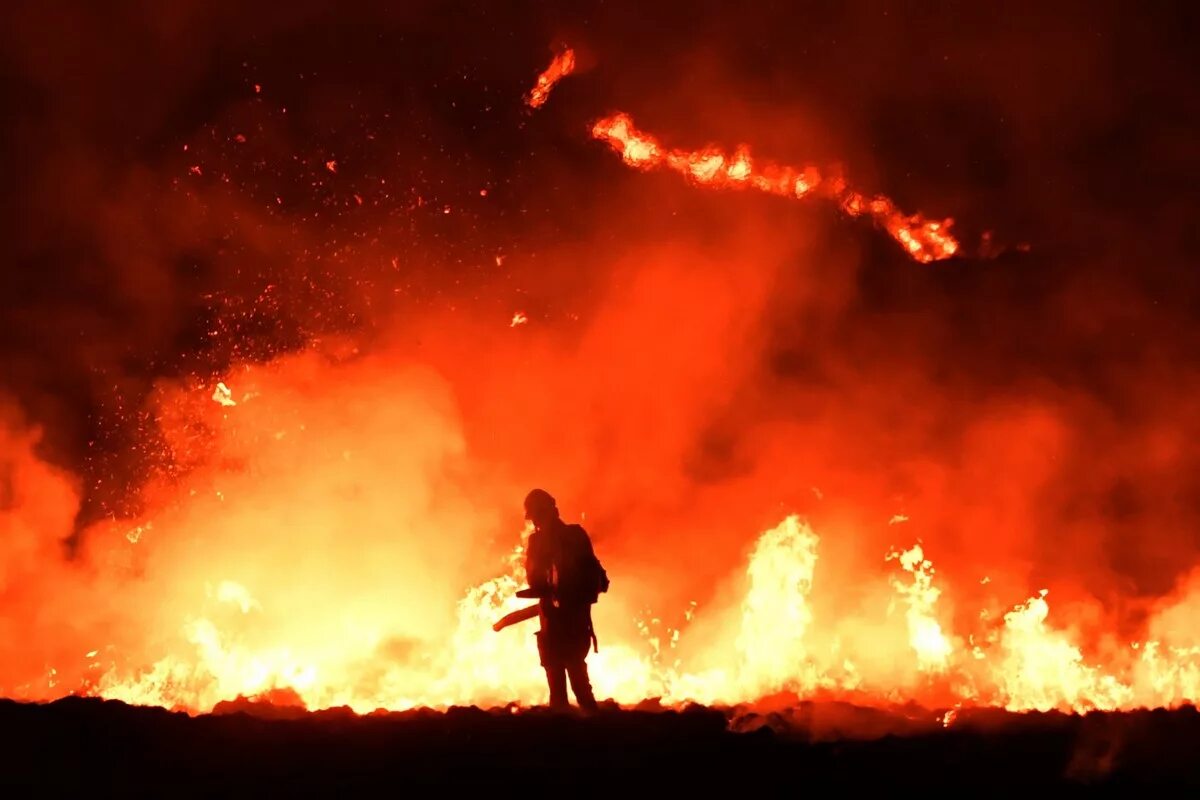 Пожарный на фоне пожара. Пожары в Великобритании. Человек на фоне пожара. Пожар фон.